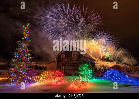 Während des Yukon Sourdough Rendezvous Festivals in Whitehorse, Yukon, Kanada, explodiert ein Feuerwerk über einer Hütte Stockfoto