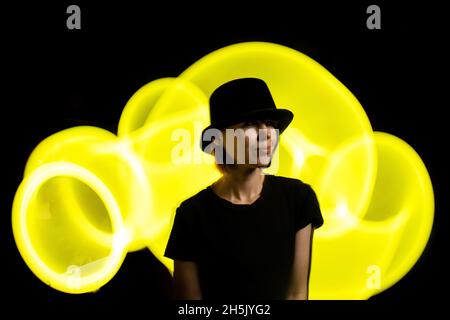 Eine Frau im Dunkeln in einem bunten Licht. Das Konzept von Energie, Aura. Stockfoto