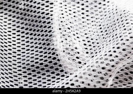 Weißes Futter in Kleidung in einem Loch, Makro. Stockfoto