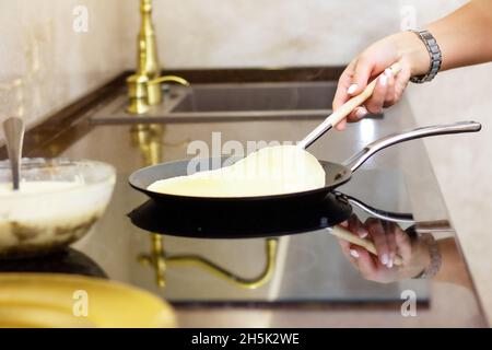 Frau bereitet russische Pfannkuchen in der Küche, Nahaufnahme. Das Konzept der russischen Küche, Kochen, Maslenitsa Urlaub. Hausgemachte, gesunde Speisen. Stockfoto