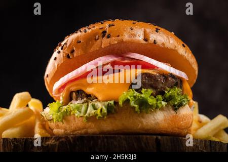 Gegrillter Beef Burger mit Pommes auf dunklem Hintergrund Stockfoto
