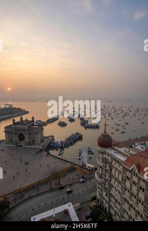 Sonnenaufgang über dem Hafen mit dem Gateway of India und dem Taj Mahal Palace Hotel im Morgengrauen; Mumbai, Bombay, Indien Stockfoto