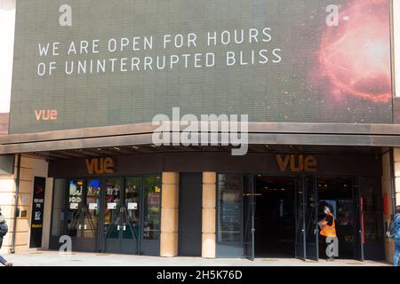 Die Menschen kommen an einer Nachricht vorbei, die über den offenen Türen eines Vue-Kinos in London angezeigt wird, da Innenräume wie Museen und Kinos wieder geöffnet werden dürfen. Stockfoto