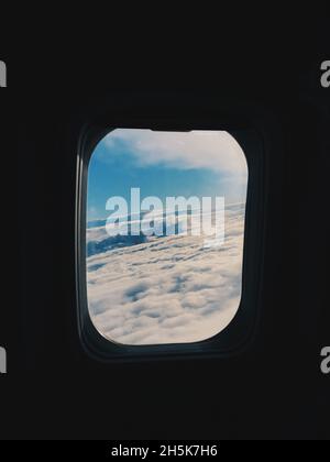 Wolken durch das Fenster eines Flugzeugs gesehen Stockfoto