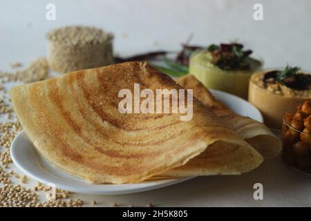 Sorghum Pfannkuchen. Knusprige Pfannkuchen aus Vollkorn-Sorghum und Leinenschalen. Im Volksmund als Jowar dosa bekannt. Serviert mit Kichererbsen-Masala und Gewürzen. Stockfoto