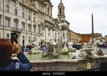 Blick von hinten aufgenommen von einem Touristen, der Fotos von Fontana del Moro auf der Piazza Navona macht; Rom, Latium, Italien Stockfoto