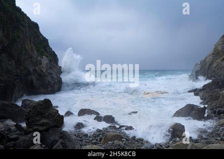 Große Sturmsurfen mit Wellen, die gegen die felsige Küste an der Küste in Big Sur, Big Sur, Kalifornien, USA, krachen Stockfoto