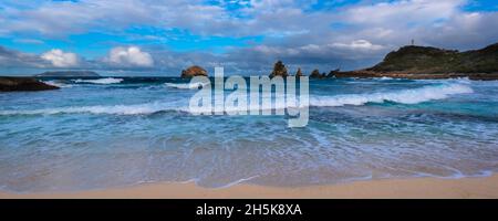 Wellen und Meereswellen treffen auf den Sandstrand von Grande-Terre mit dem Grand-Croix in der Ferne an der Spitze der Pointe des Chateaux Stockfoto