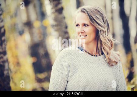 Ein Porträt einer schönen reifen Frau in einem Stadtpark an einem warmen Herbstnachmittag; St. Albert, Alberta, Kanada Stockfoto