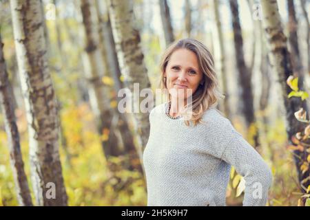 Ein Porträt einer schönen reifen Frau in einem Stadtpark an einem warmen Herbstnachmittag; St. Albert, Alberta, Kanada Stockfoto