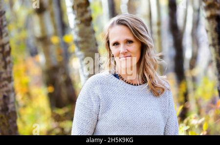 Ein Porträt einer schönen reifen Frau in einem Stadtpark an einem warmen Herbstnachmittag; St. Albert, Alberta, Kanada Stockfoto