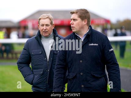 Trainer Dan Skelton (rechts) und Nick Skelton auf der Rennbahn Bangor-on-Dee. Bilddatum: Mittwoch, 10. November 2021. Stockfoto