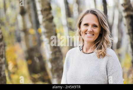 Ein Porträt einer schönen reifen Frau in einem Stadtpark an einem warmen Herbstnachmittag; St. Albert, Alberta, Kanada Stockfoto