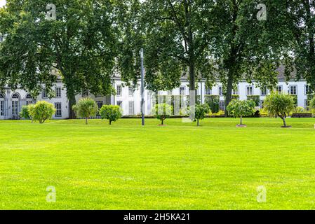 Üppiger Rasen im Park vor einem schönen historischen Palast. Stockfoto