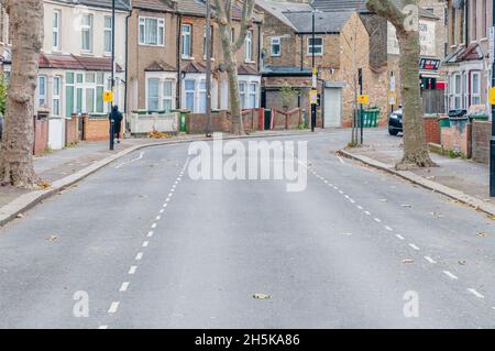 Eine verlassene britische Straße mit geschlossenen Geschäften an einem hellen sonnigen Tag Stockfoto