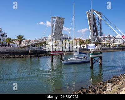 Lagos, Algarve, Portugal - 10 2021. November: Yacht fährt über die offene Bascule-Fußgängerbrücke von Marina De Lagos Stockfoto