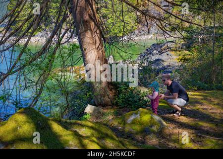 Vater und junge Tochter erkunden Twin Islands, in der Nähe von Deep Cove, North Vancouver, BC, Kanada; North Vancouver, British Columbia, Kanada Stockfoto