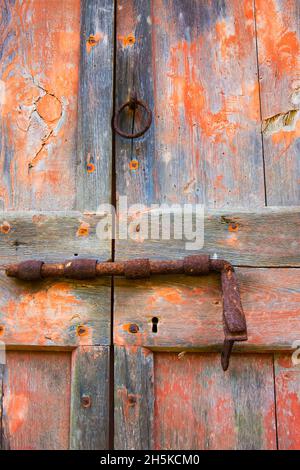 Alte Türverriegelung, rostig und auf verwitterten Holztüren; Toskana, Italien Stockfoto