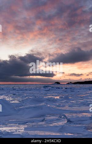 Wunderschöner Sonnenuntergang über dem Lake Superior mit Eisformationen im Winter; Wawa, Ontario, Kanada Stockfoto