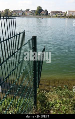 Maschendraht markiert die schweizerische deutsche Grenze am Rheinhafen Kleinhüningen mit dem schweizerisch-deutschen französischen Grenzdreieck in der Mitte des Flusses Stockfoto