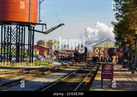 Strasburg, PA, USA - 7. November 2021: Eine Dampflokomotive an der Strasburg Rail Road rollt zum Wasserbehälter. Stockfoto