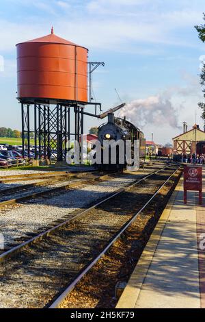 Strasburg, PA, USA - 7. November 2021: Eine Dampflokomotive an der Strasburg Rail Road rollt zum Wasserbehälter. Stockfoto