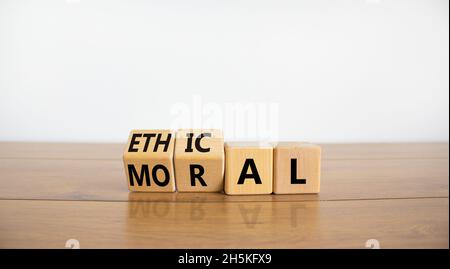 Ethisches oder moralisches Symbol. Drehten Holzwürfel und änderten das Wort „oral“ in „ethisch“ auf einem schönen Holztisch mit weißem Hintergrund. Wirtschaft und eth Stockfoto