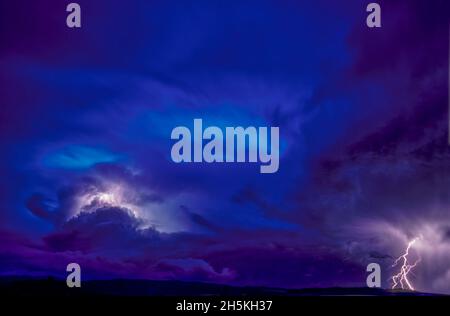 Eine 10-minütige Exposition bei einem stark bewölkten Mitternachtshimmel, zeigt einen vorübergehenden Gewitter; Montana, USA Stockfoto