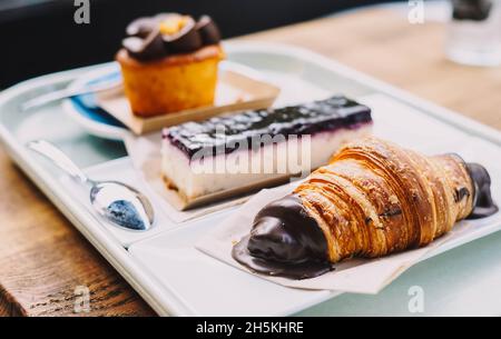 Ein Croissant, eine Portion Käsekuchen und ein Muffin mit Karottenkuchen Stockfoto