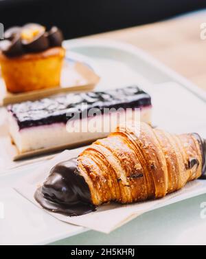 Ein Croissant, eine Portion Käsekuchen und ein Muffin mit Karottenkuchen Stockfoto