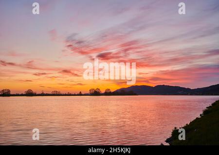 Bunt leuchtende Wolken bei Sonnenuntergang über dem Fluss Danubia, der Oberpfalz, dem Bayerischen Wald; Bayern, Deutschland Stockfoto