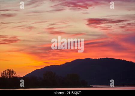 Bunt leuchtende Wolken bei Sonnenuntergang über dem Fluss Danubia, der Oberpfalz, dem Bayerischen Wald; Bayern, Deutschland Stockfoto