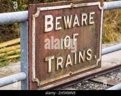 Nahaufnahme des alten Schildes „Beware of Trains“ bei Heritage Railway Company, Großbritannien. Stockfoto