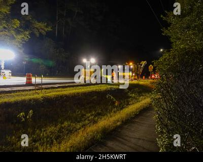 Crews, die unter Einsatz von starker Außenbeleuchtung umfangreiche Nachtarbeiten an einem Straßenprojekt mit einer Leistung von 5,5 Millionen Einwohnern in der Northwest 34th Street, von der 16th Avenue bis zur 13th Street, durchführen. Crews arbeiten fast die ganze Nacht, während Stunden leichteren Verkehrs. Der voraussichtliche Fertigstellungstermin ist irgendwann im Jahr 2022. Gainesville, Alachua County, Florida, USA. Stockfoto