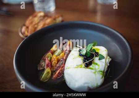 Selektiv aus einem wunderschön dekorierten veganen Gericht in einer schwarzen Schüssel Stockfoto