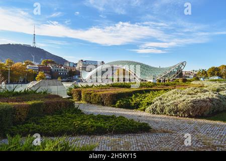 Tiflis, Georgien - 24. Oktober 2021: Der Rike Park in der georgischen Hauptstadt mit der Brücke des Friedens, bogenförmige Fußgängerbrücke über die Kura Stockfoto