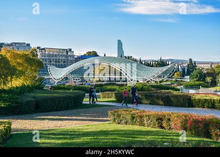 Tiflis, Georgien - 24. Oktober 2021: Der Rike Park in der georgischen Hauptstadt mit der Brücke des Friedens, bogenförmige Fußgängerbrücke über die Kura Stockfoto