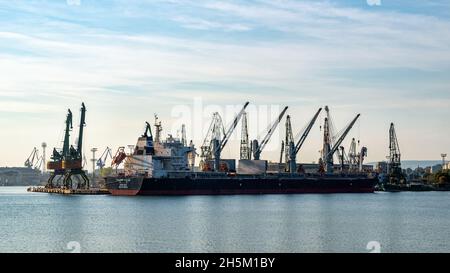 Varna, Bulgarien, 22. Oktober 2021. Pacific Valor Bulk Carrier mit eigenen 4 eingebauten Kranen während der Verladung im kommerziellen Seehafen von Varna. Stockfoto