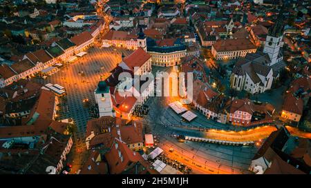 Blick aus der Vogelperspektive auf das historische Stadtzentrum von Sibiu, Rumänien bei Sonnenuntergang. Drohnenfotografie von oben mit der evangelischen Kathedrale. Stockfoto