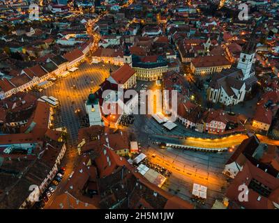 Blick aus der Vogelperspektive auf das historische Stadtzentrum von Sibiu, Rumänien bei Sonnenuntergang. Drohnenfotografie von oben mit der evangelischen Kathedrale. Stockfoto