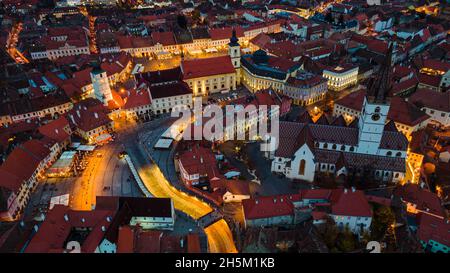 Blick aus der Vogelperspektive auf das historische Stadtzentrum von Sibiu, Rumänien bei Sonnenuntergang. Drohnenfotografie von oben mit der evangelischen Kathedrale. Stockfoto