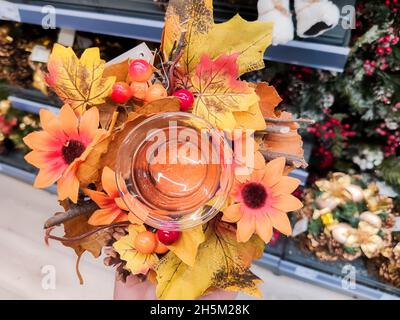 Das Mädchen, das in der Mall ist, hält einen Kranz aus Herbstblättern Stockfoto