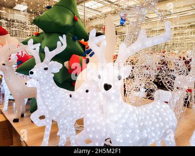 Weihnachtsrentiere, die mit Girlanden geschmückt sind, befinden sich auf der Theke in der Mall Stockfoto