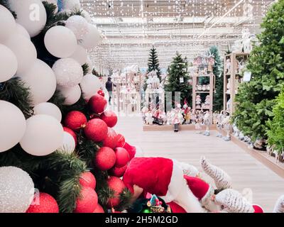 Blick auf die Einkaufszentrums-Halle, die mit Weihnachtsbäumen mit Spielzeug und verschiedenen Girlanden geschmückt ist Stockfoto