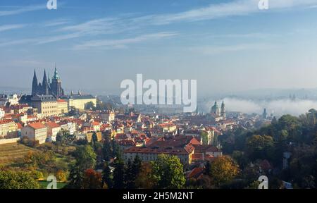 Altstadt von Prag mit der Kleinseite und dem Fluss, der an einem sonnigen Herbsttag in Nebel gehüllt ist. Stockfoto