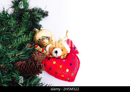 Weihnachtsarrangement mit einem gefüllten Teddybär, goldenem Weihnachtsball und Kiefernästen Stockfoto