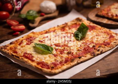 Rechteckige Form und dünne handgemachte Margherita Pizza aus nächster Nähe Stockfoto