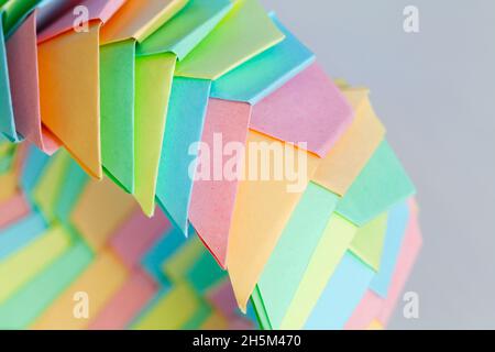 Farbenfroher Origami-Ring, abstrakte parametrische Struktur aus Papierblättern, Nahaufnahme mit selektivem Weichfokus Stockfoto