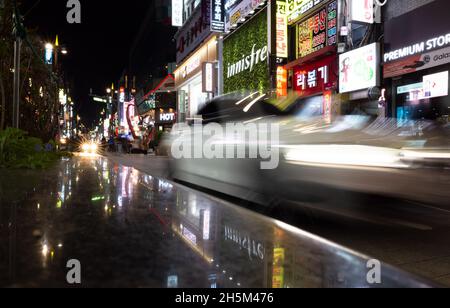 Busan, Südkorea - 23. März 2018: Blick auf die nächtliche Stadtstraße mit heller Werbebeleuchtung und verschwommenen Autos Stockfoto