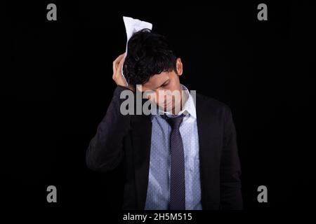 Besorgt, gestresst und gelangweilt Geschäftsmann erliegt Stress. Junger erwachsener latein machte sich Sorgen um seinen Job. Verwirrt. Stockfoto